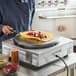 A chef using a Carnival King crepe maker to cook a crepe with fruit on it.