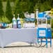 A white table with a Carnival King snow cone machine and bottles of liquid on it.