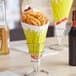 A Carnival King cardboard fry cone filled with French fries on a table in a restaurant.