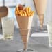 A Carnival King Kraft paper cone filled with french fries on a table.