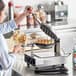 A woman using a Carnival King bubble waffle maker to make waffles.