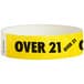 A yellow paper wristband with black "OVER 21" text.