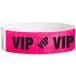 A pink paper wristband with the black text "VIP" and a white border.