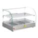 A Carnival King countertop glass display case with metal racks of hot food.