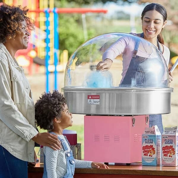 girl holding cotton candy at a carnival