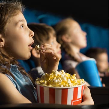 kids eating popcorn in a movie theatre